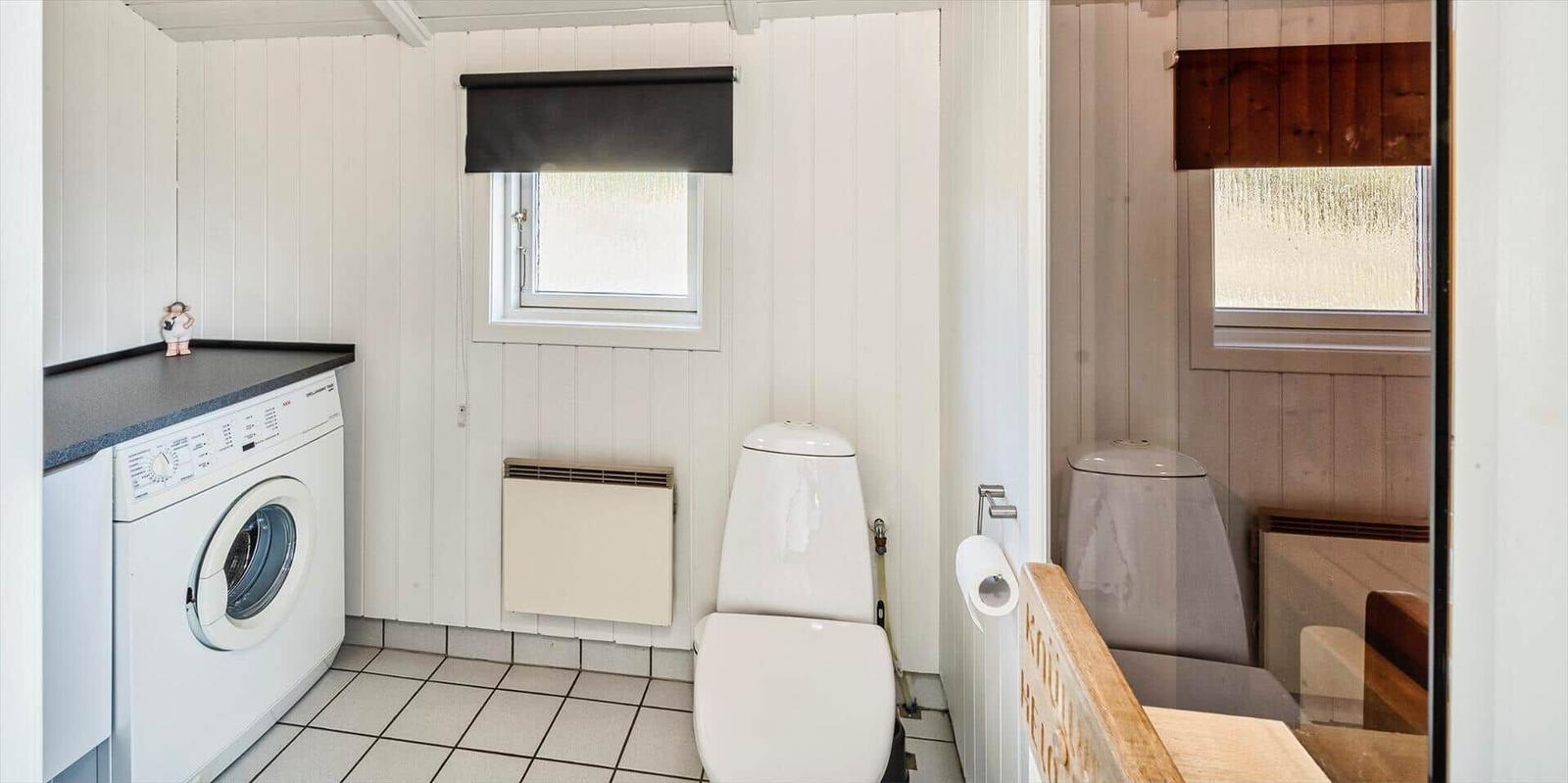 Wohnung mit Waschmaschine, Toilette und Bad mit Dusche.