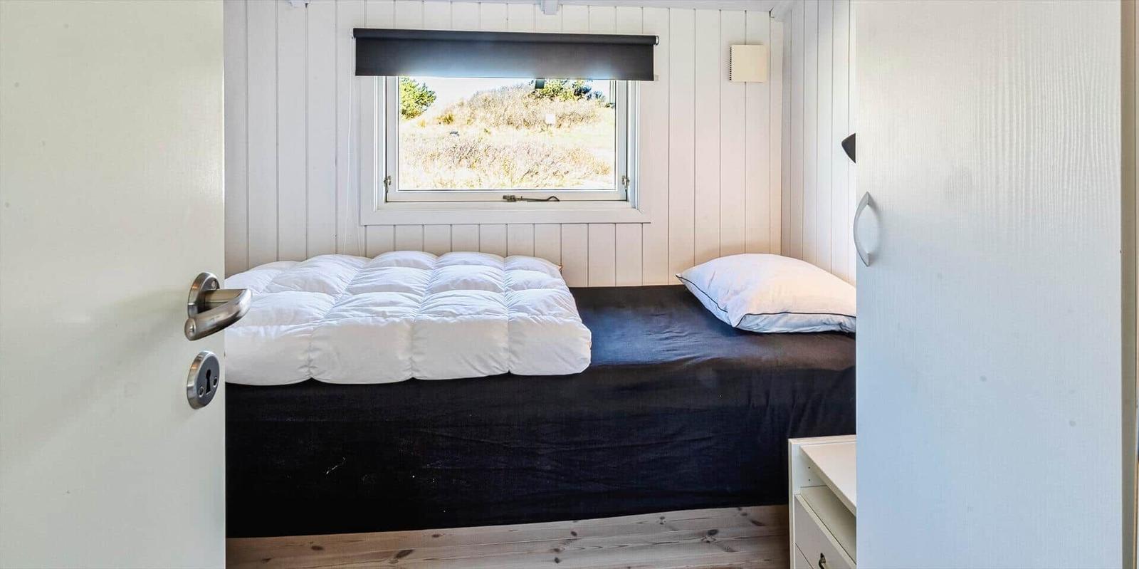 Schlafzimmer mit Bett, Fenster und Schrank.
