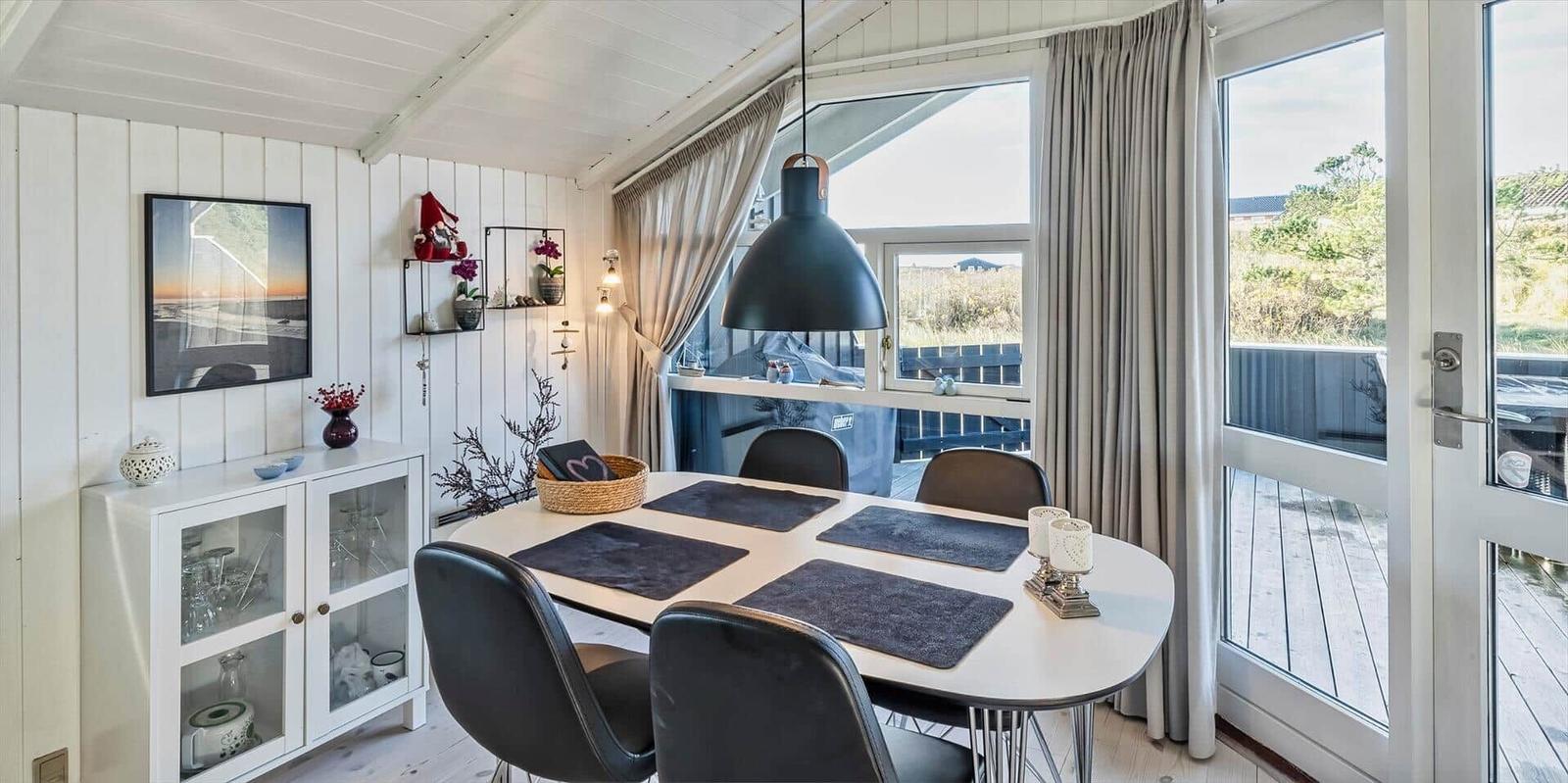 Esszimmer mit Tisch, Stühlen und Blick auf Balkon
