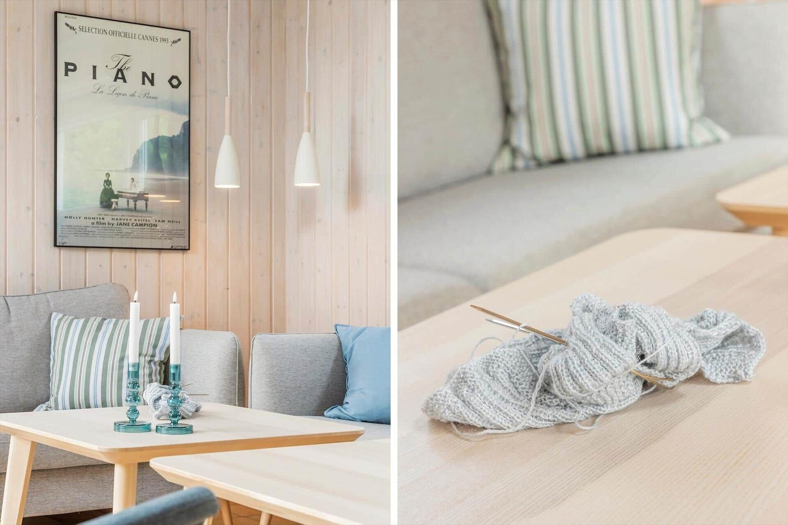 Living room with sofa, table, and wall poster. Knitting project lies on the table.