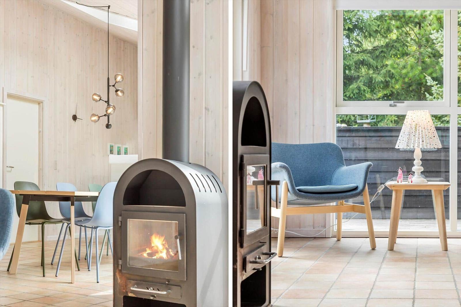 Wood-burning stove, seating area, and window with view of trees.