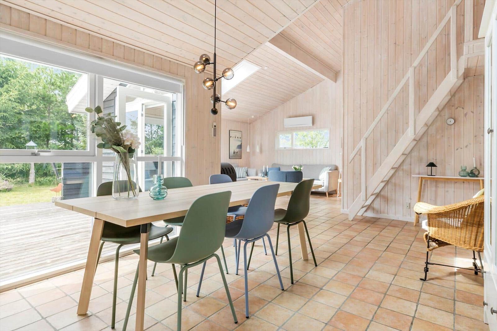 Dining area with table, chairs, and view of the terrace.