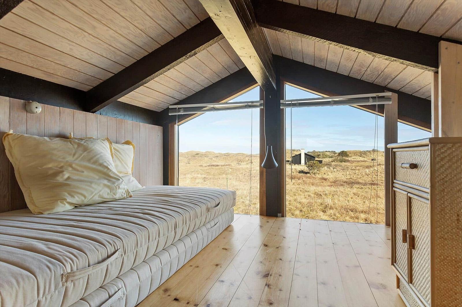 Bedroom with bed and view of the landscape.