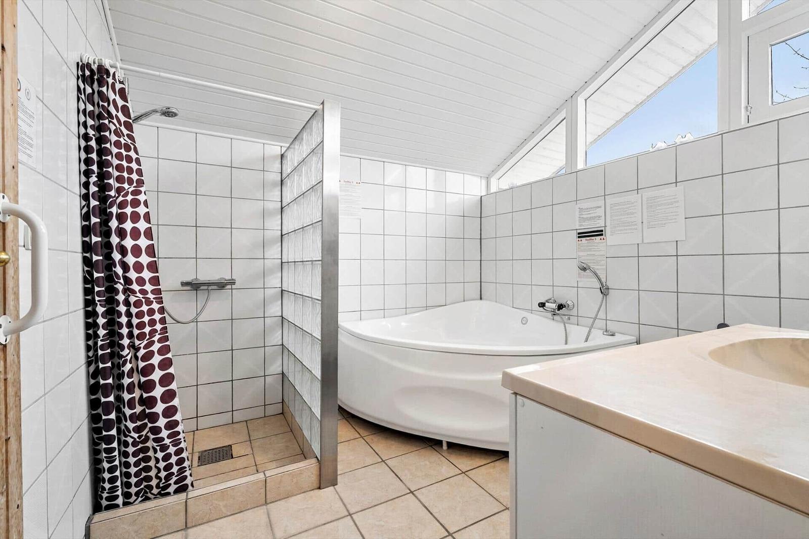Dusche mit Duschvorhang, Badewanne und Waschbecken.