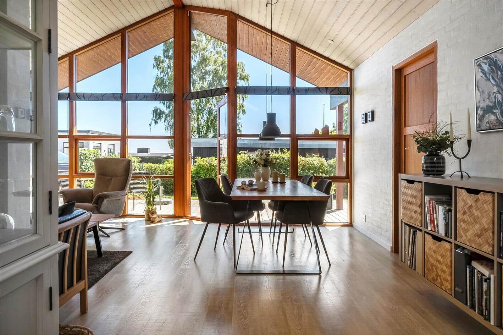 Esszimmer mit Holztisch, Stühlen und großem Fensterblick