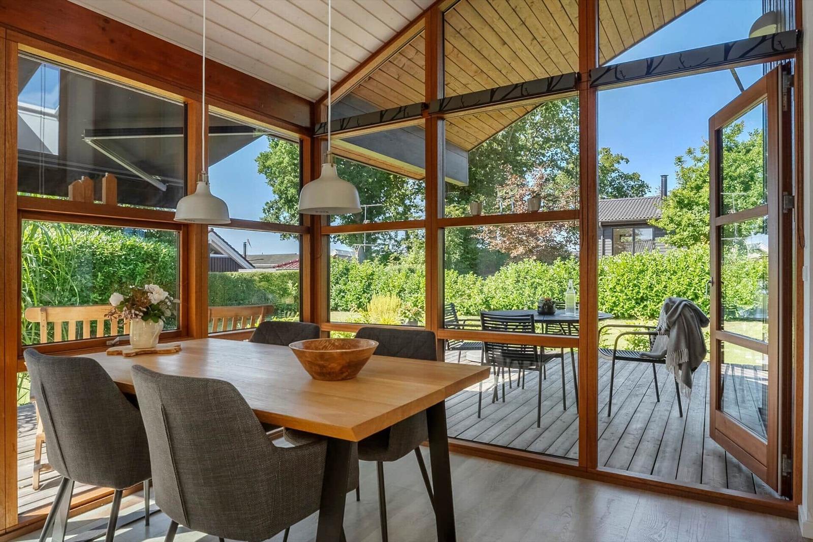 Esszimmer mit Holztisch, Stühlen und Blick auf die Terrasse.