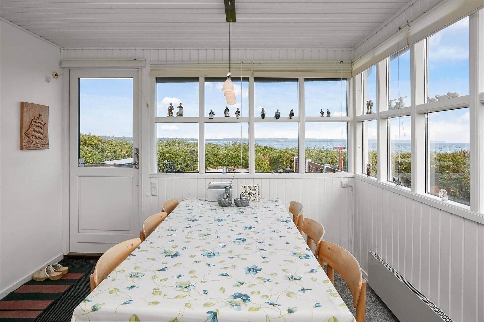 Esszimmer mit Blick aufs Meer und großen Fenstern.