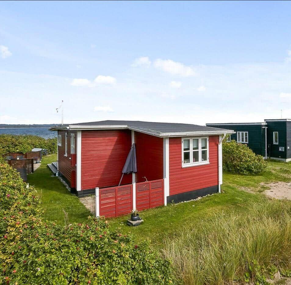 Rotes Strandhaus mit Terrasse und Blick aufs Wasser
