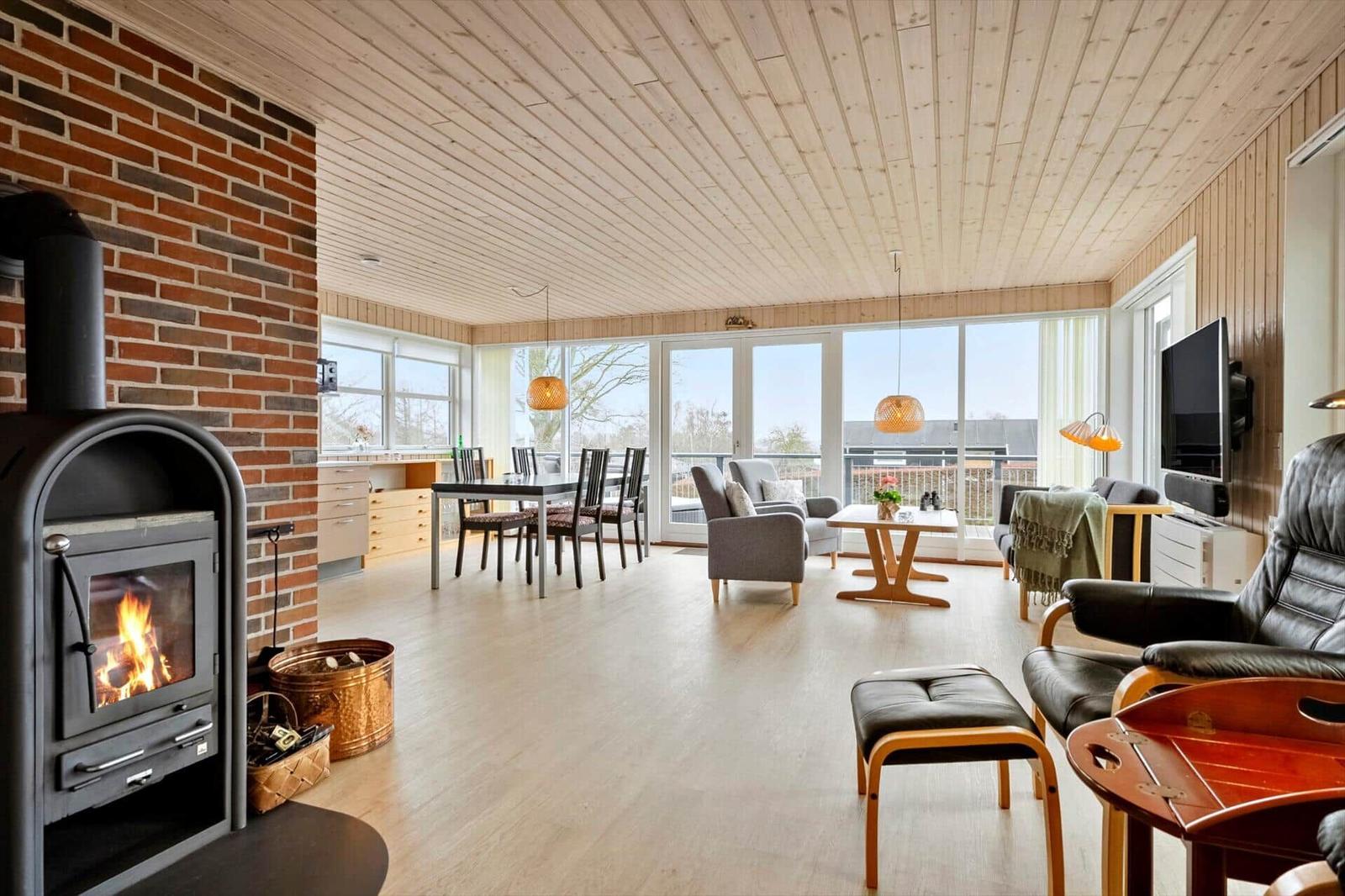 Wohn- und Essbereich mit Kamin, Balkon und moderner Einrichtung.