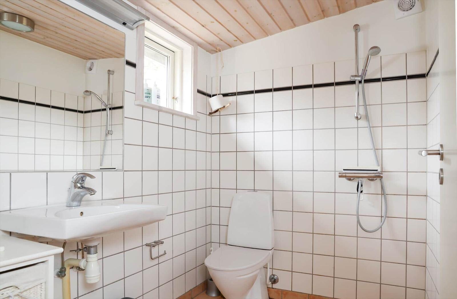 Badezimmer mit Dusche, Toilette und Waschbecken.