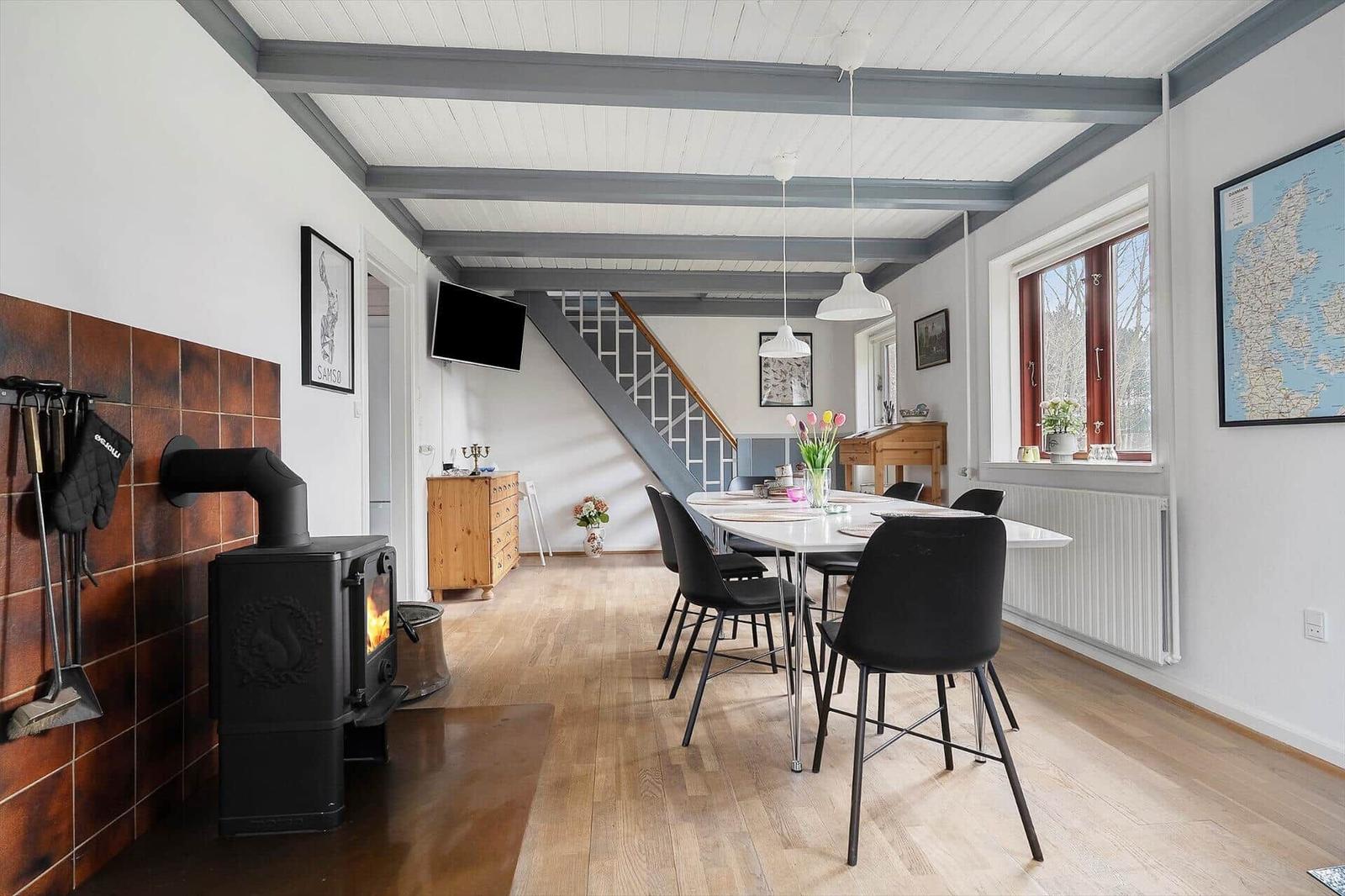 Haus mit Esstisch, Kamin und Treppe zur oberen Etage.