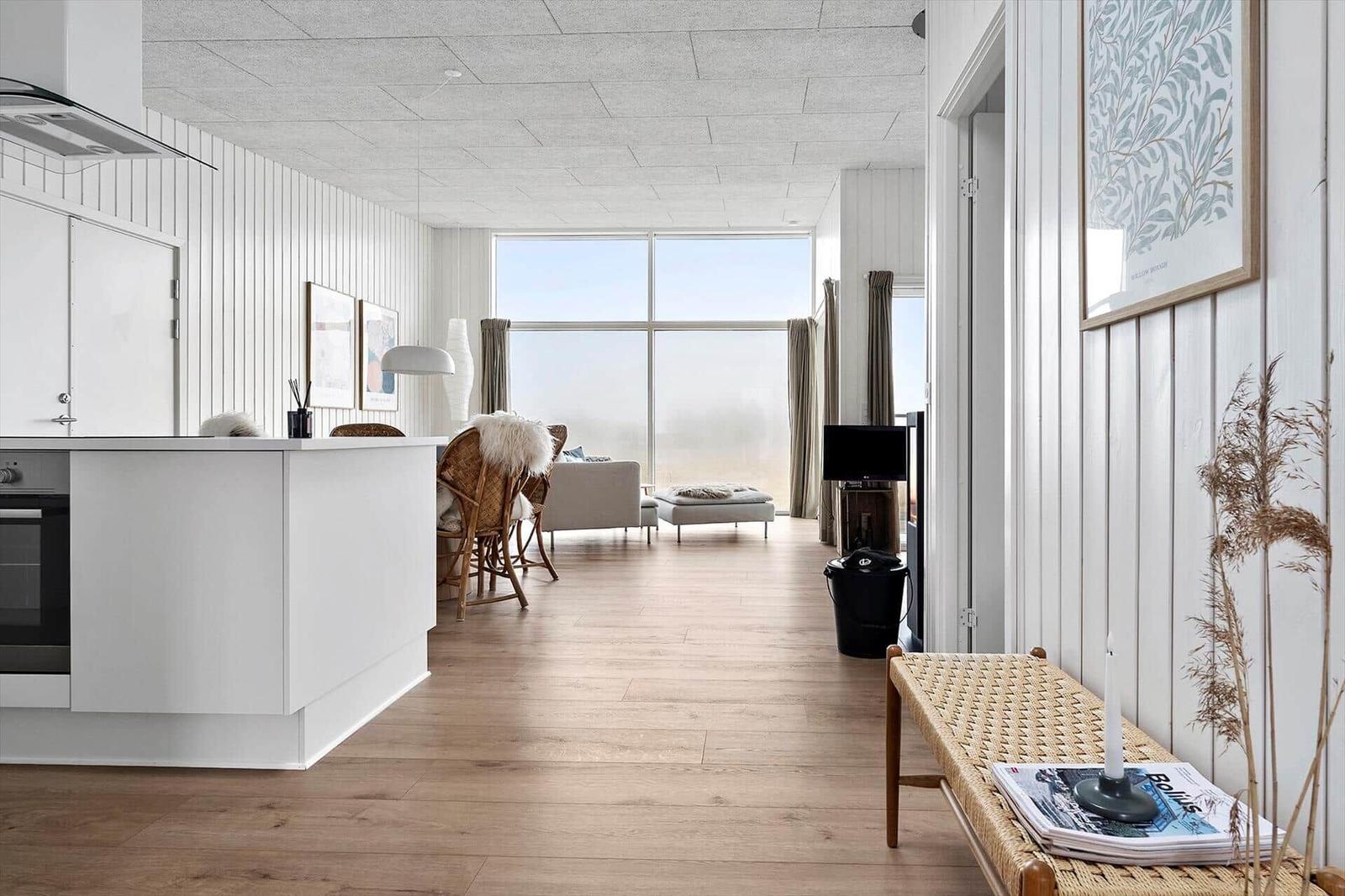 Moderne Küche mit Blick auf Wohnzimmer und großes Fenster.