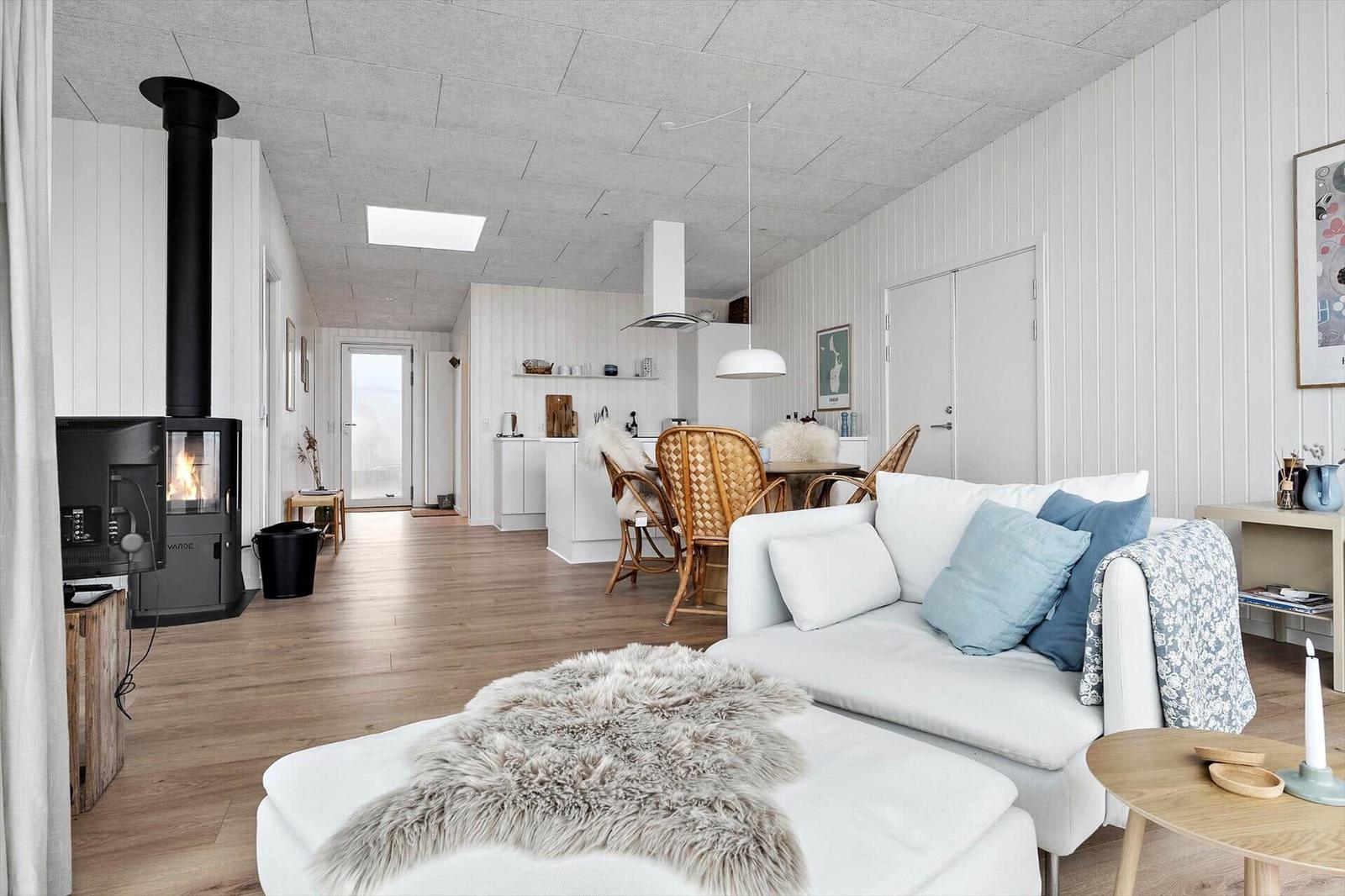 Wohn- und Essbereich mit Kamin, Sofa und Holzboden.