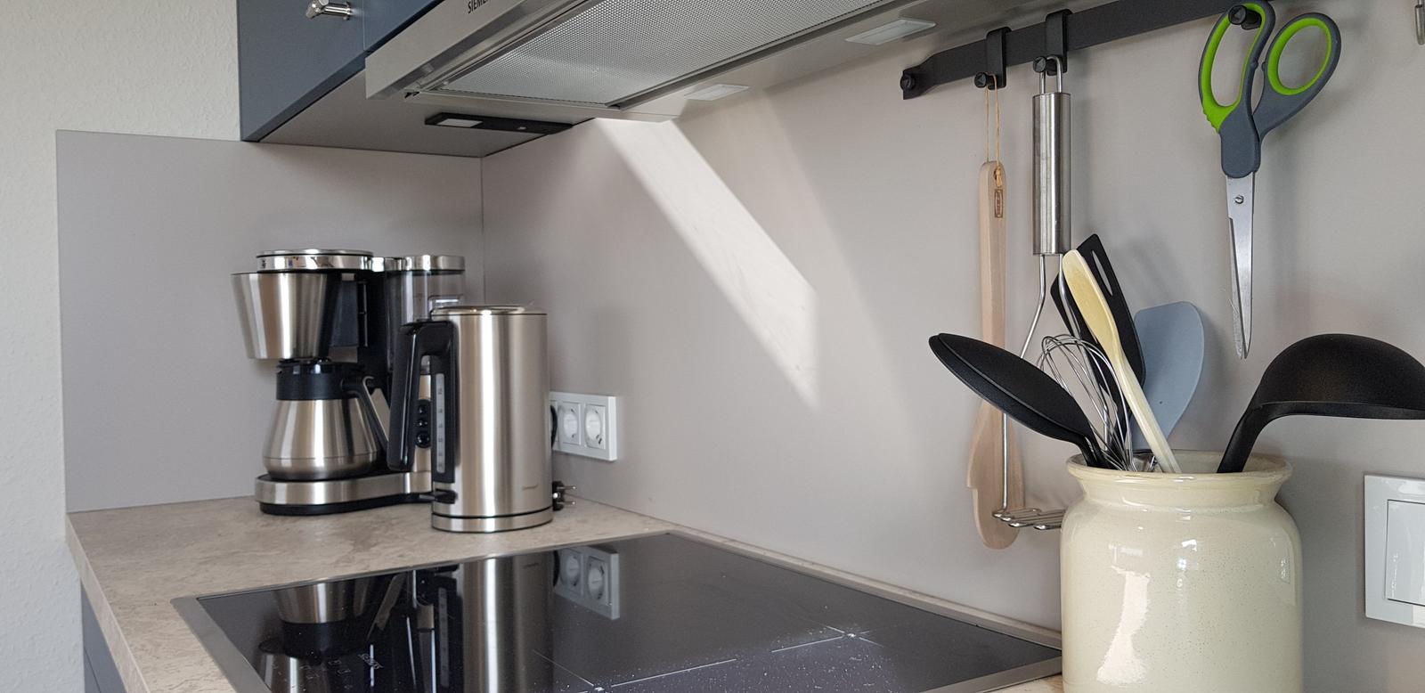 Küche mit Kaffeemaschine, Wasserkocher und Küchenutensilien.