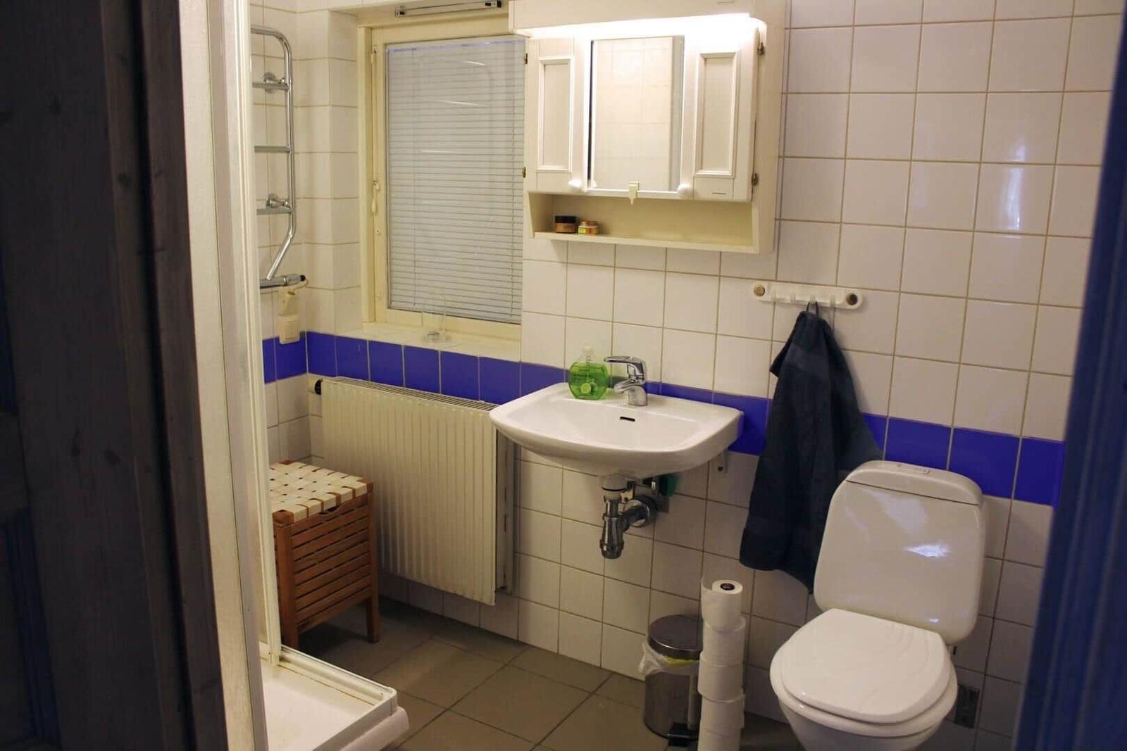 Badezimmer mit Waschbecken, Toilette und Fenster