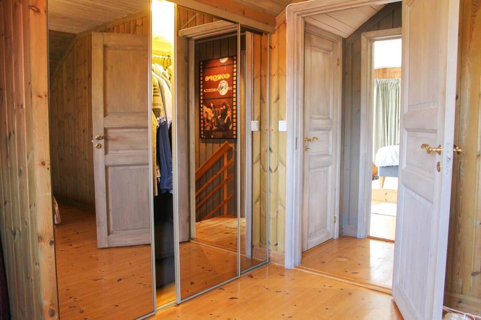 Schlafzimmer mit Kleiderschrank und Treppe. Holzwände und -boden.