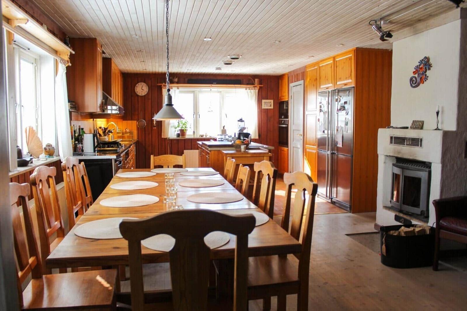 Esszimmer mit Holztisch, Stühlen und Küchenbereich.