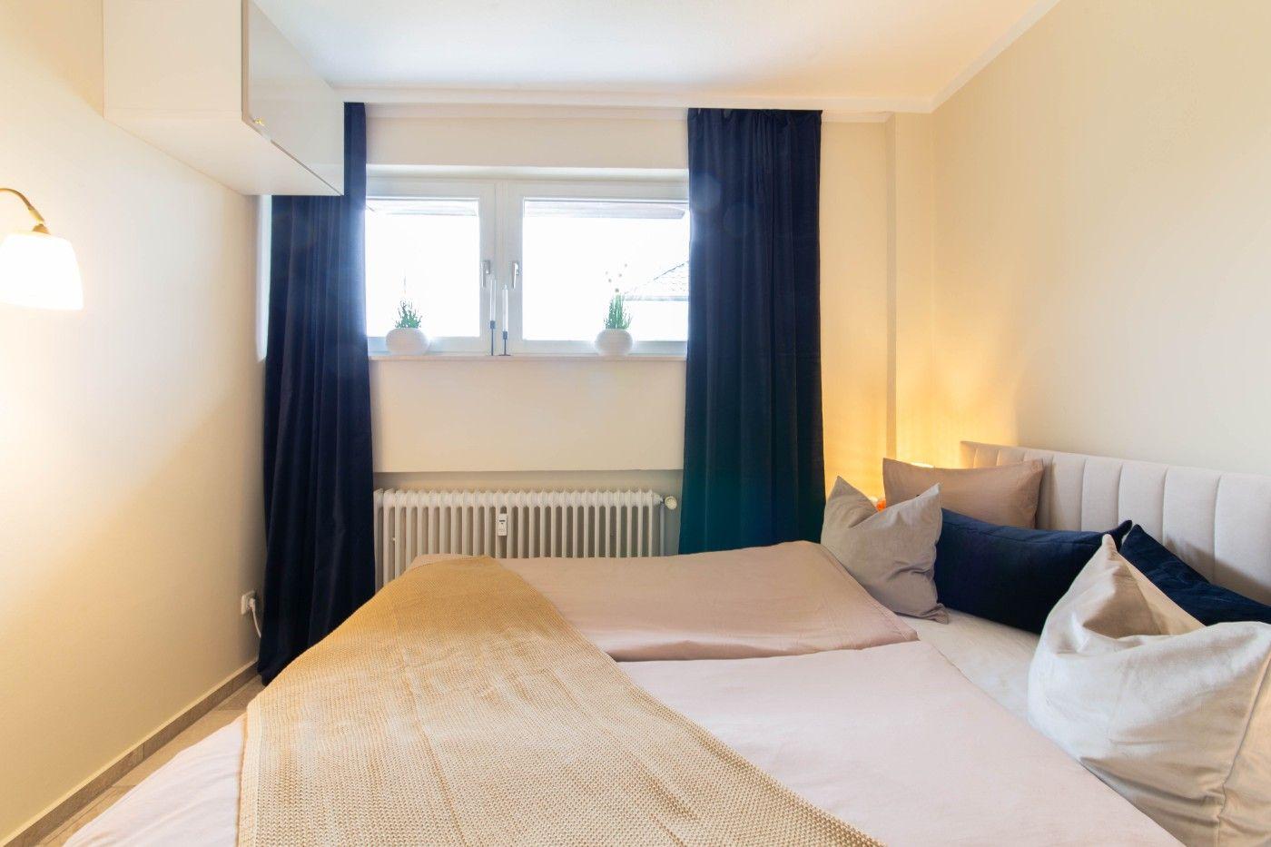 Schlafzimmer mit Bett, Fenster und Vorhängen