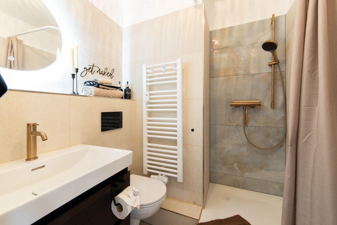 Badezimmer mit Dusche, Waschbecken und Toilette