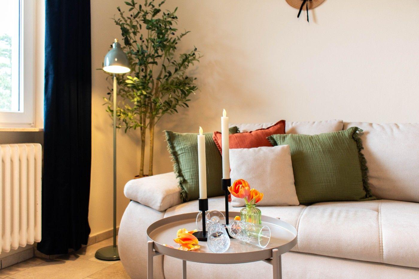 Ein Wohnzimmer mit einem Sofa, einem runden Tisch und einer Stehlampe.