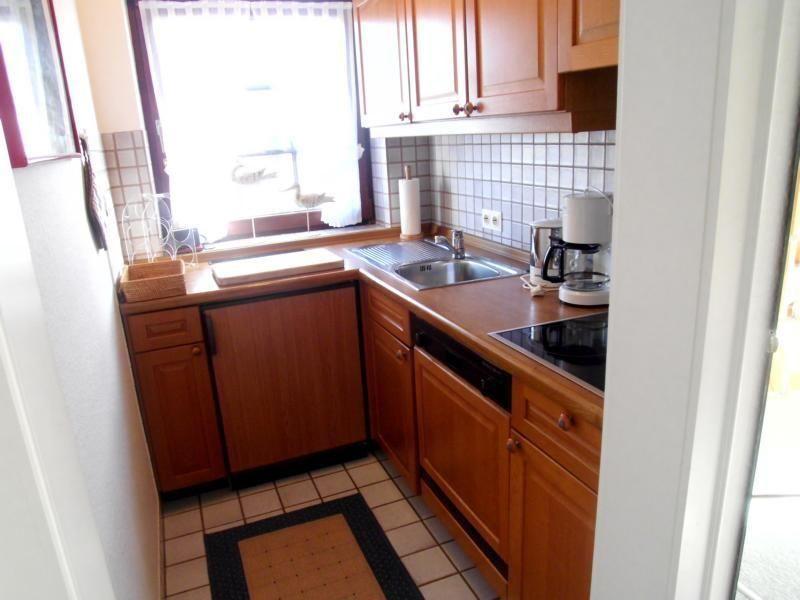 Küche mit Holzschränken, Spüle und Fenster