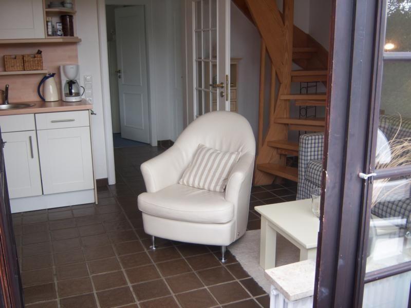 Wohnbereich mit Sitzgelegenheit und Küchenbereich im Hintergrund.