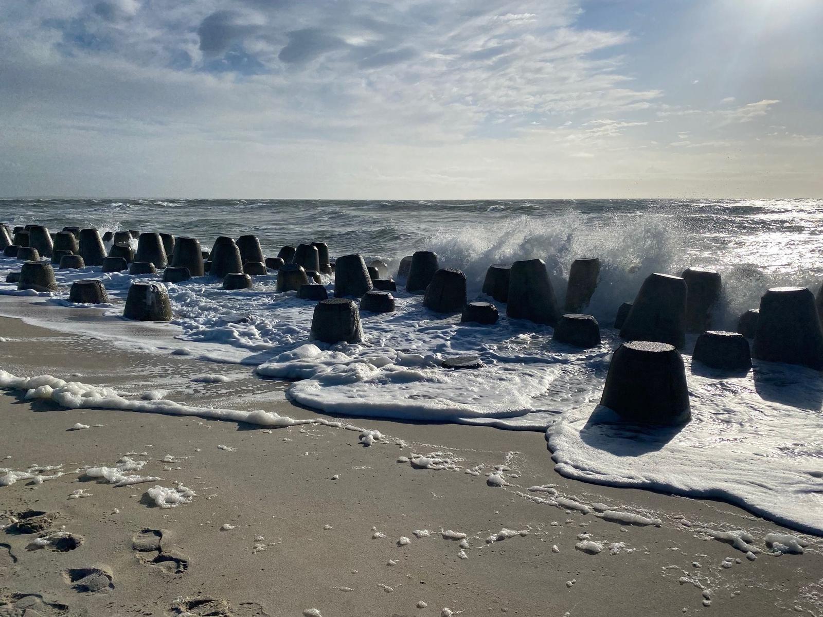 Wellen brechen an Steinen am Strand