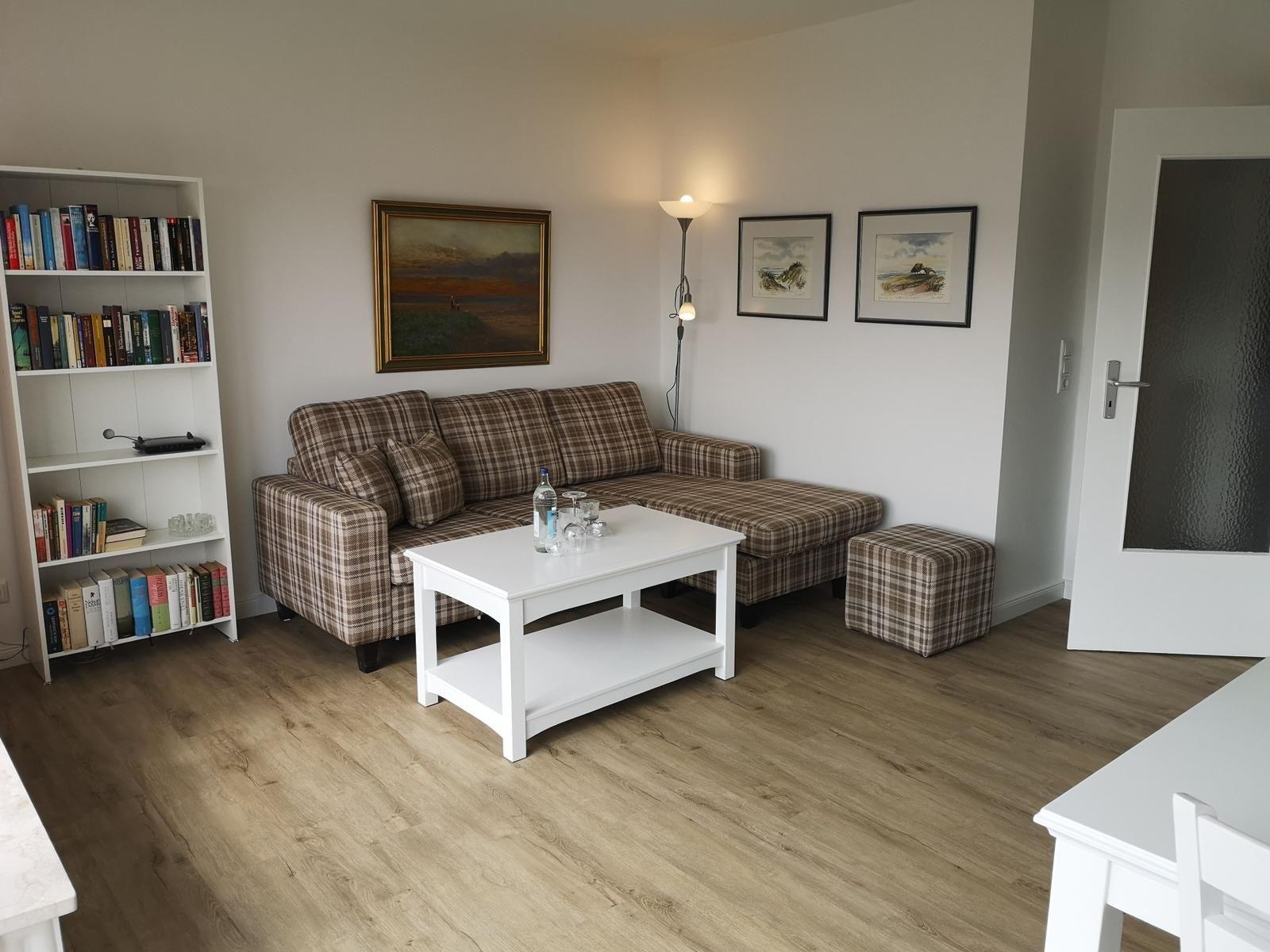 Wohnzimmer mit Sofa, Couchtisch und Bücherregal.