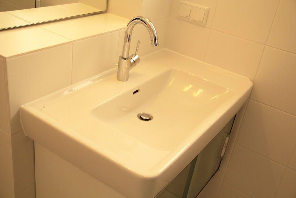 Waschbecken mit Armatur und Spiegel über dem Waschbecken