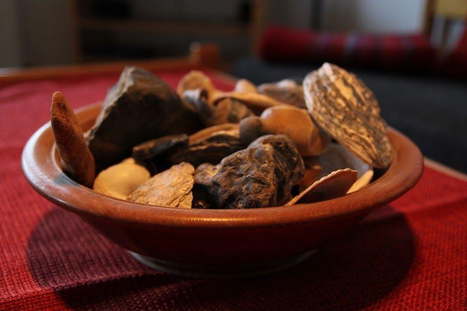 Eine Keramikschale mit Trockenfrüchten auf rotem Tischtuch.