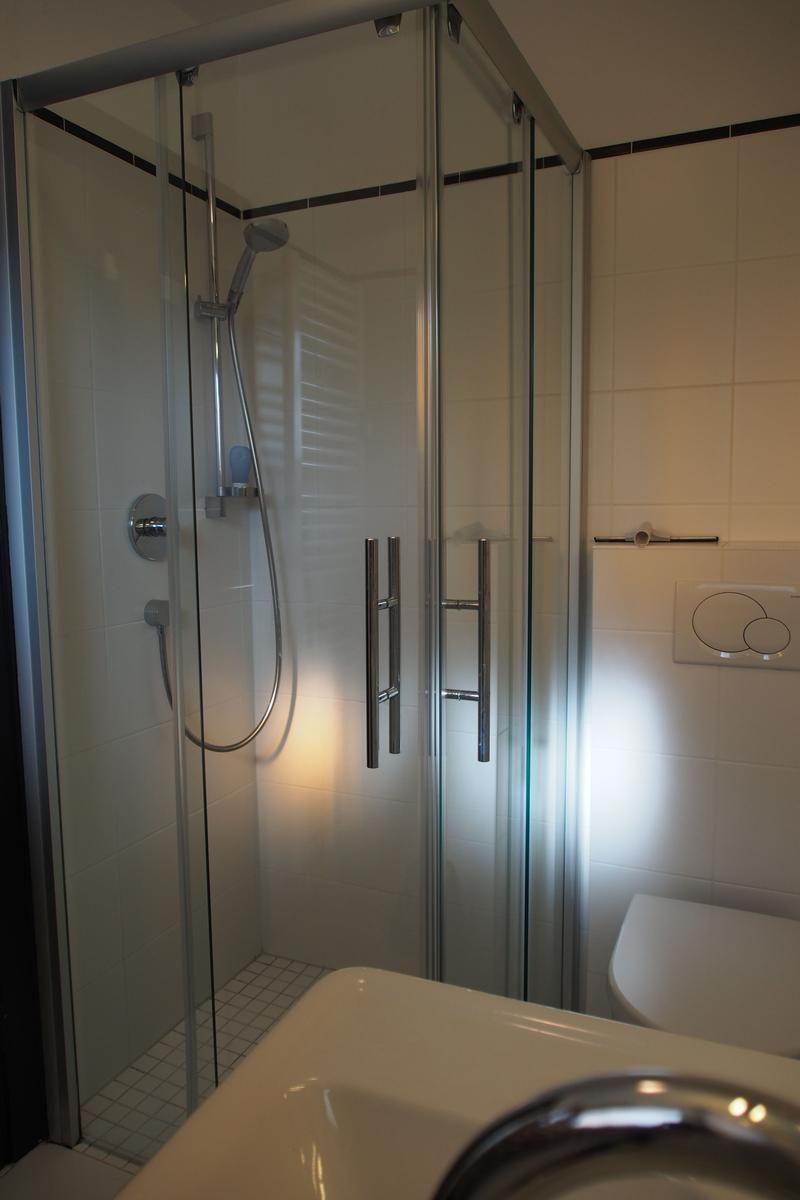 Duschkabine mit Glaswand, Toilette und Waschbecken im Badezimmer