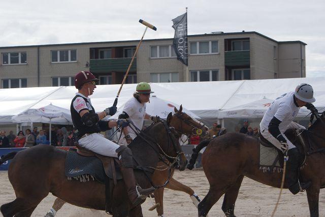 Reiter auf Pferden bei einem Polo-Spiel auf Sandplatz