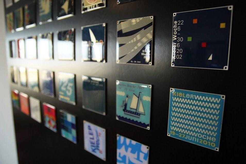 Wand mit vielen farbigen Plaketten von Kieler Woche.