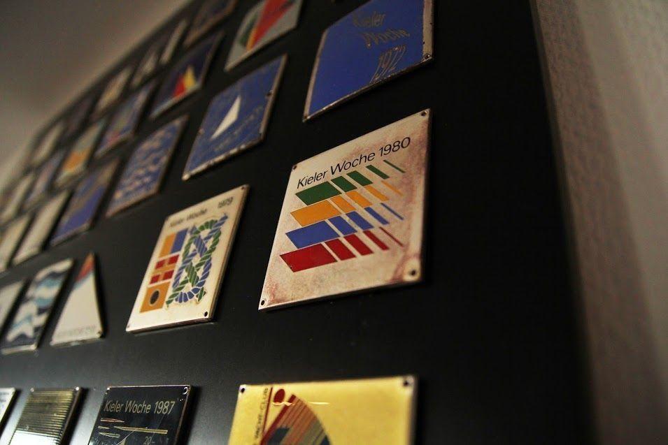 Wand mit historischen Kieler Woche-Aufklebern von 1979 bis 1980.