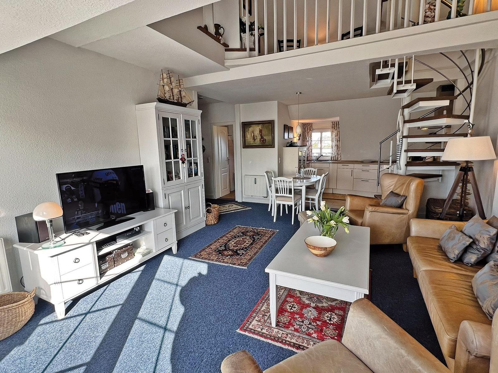 Wohn- und Essbereich mit Treppenhaus und Fernseher