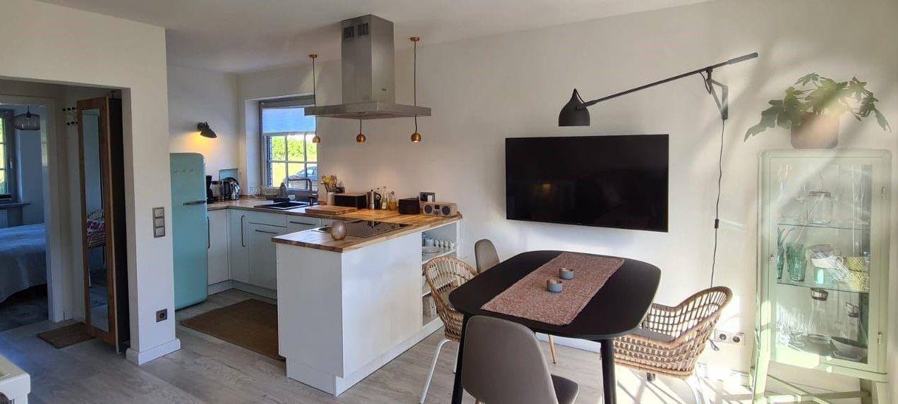 Küche mit Essbereich und Fernseher an der Wand