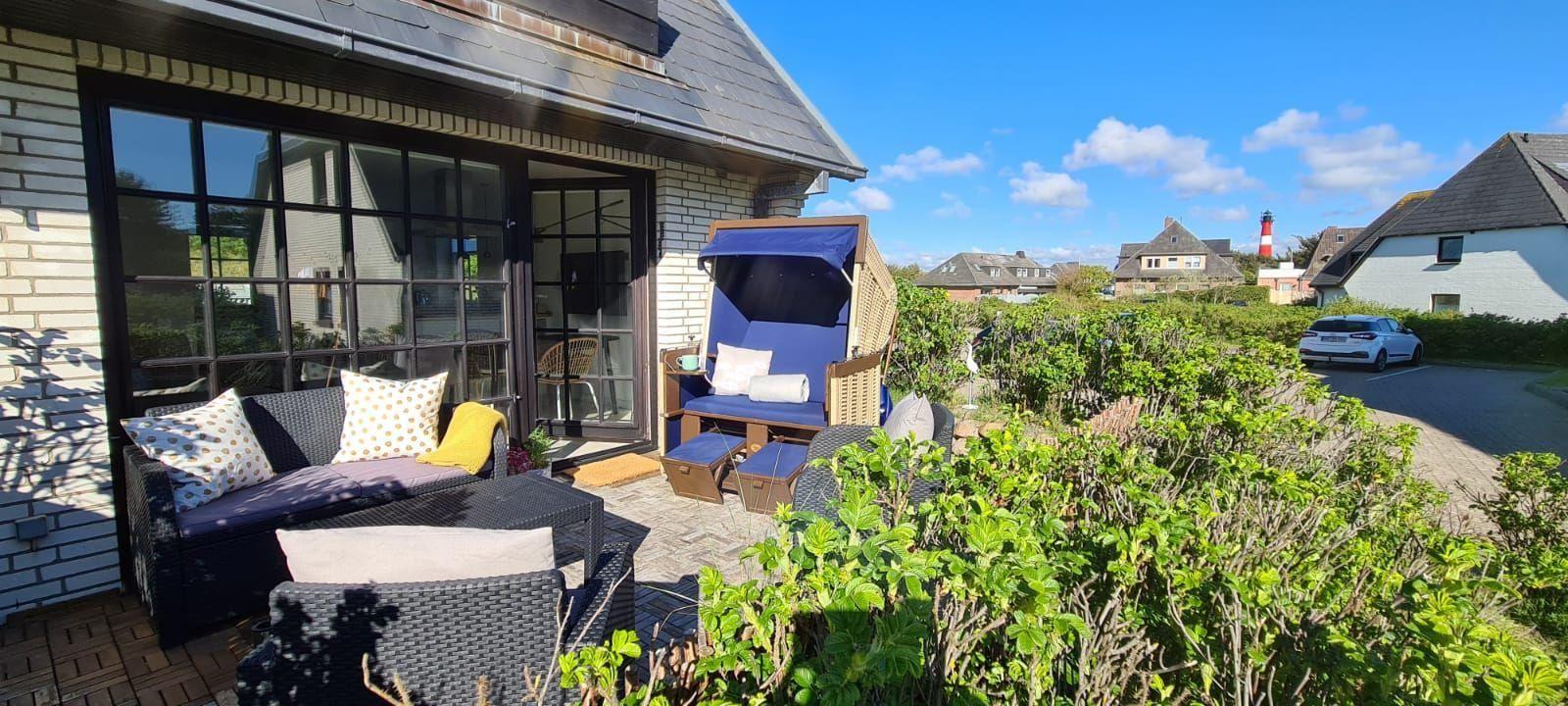 Terrasse mit Sitzgelegenheiten und Blick auf Leuchtturm