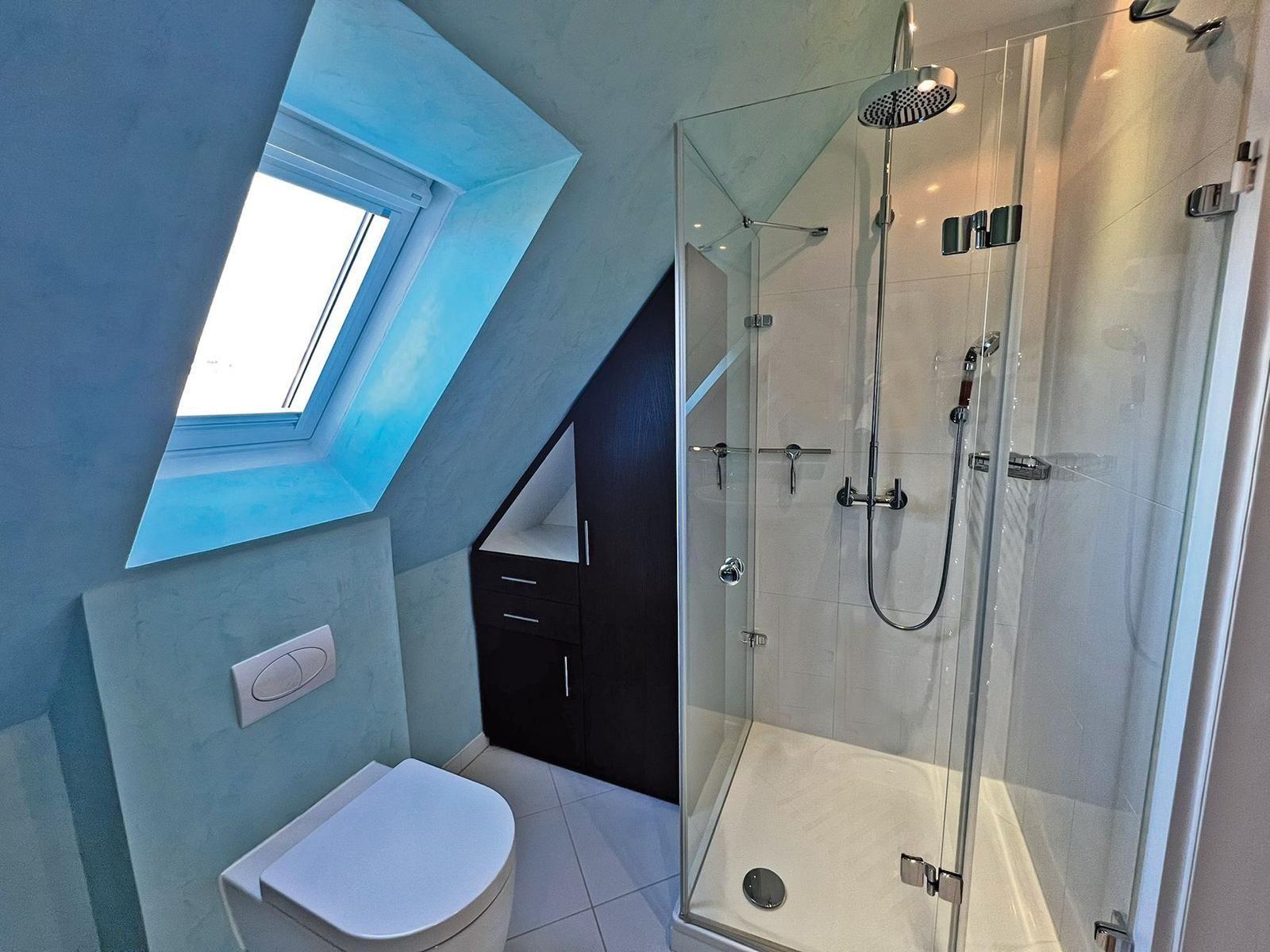 Badezimmer mit Dusche, Toilette und Dachfenster
