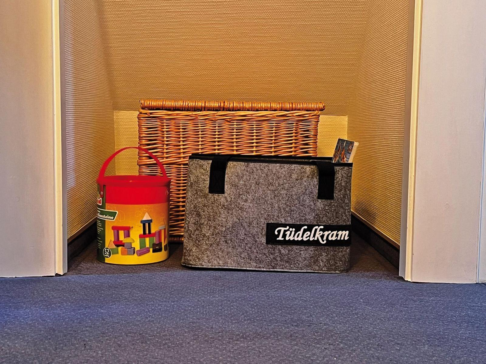 Wohnbereich mit Korb, Spielzeug und Aufbewahrungsbox.