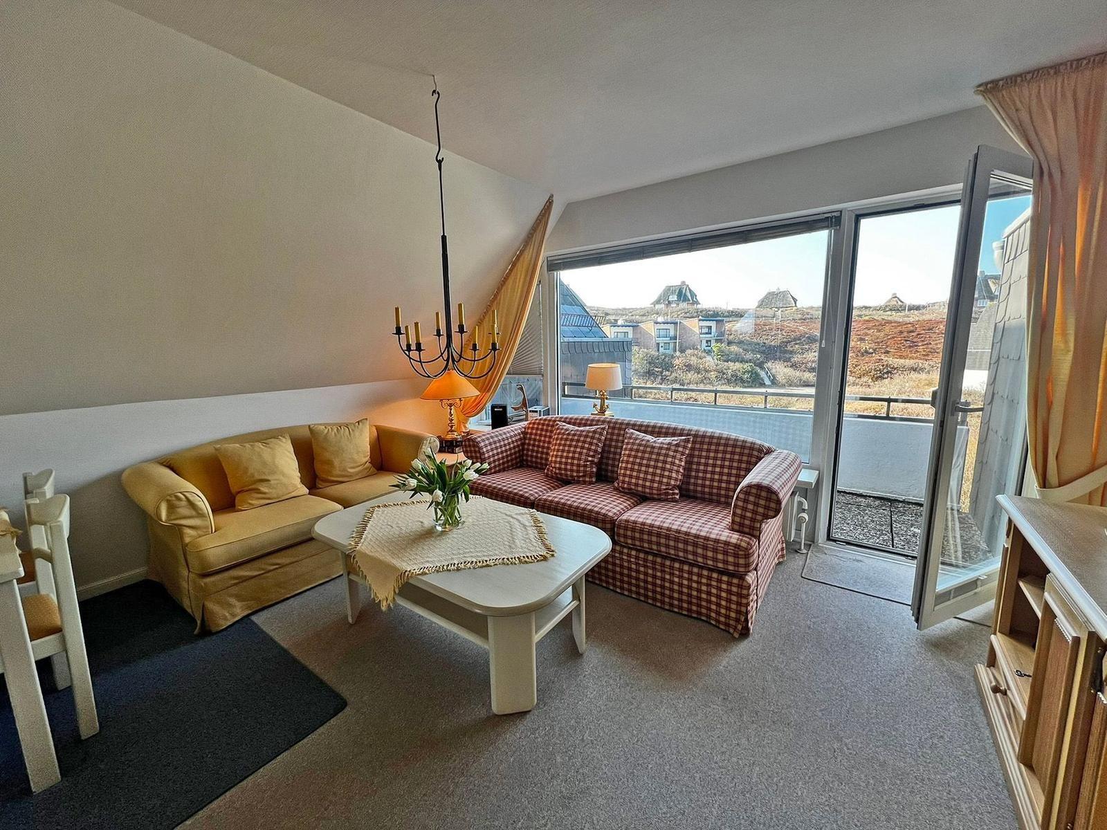 Wohnzimmer mit Sofa, Tisch und Balkon. Blick auf die Landschaft.