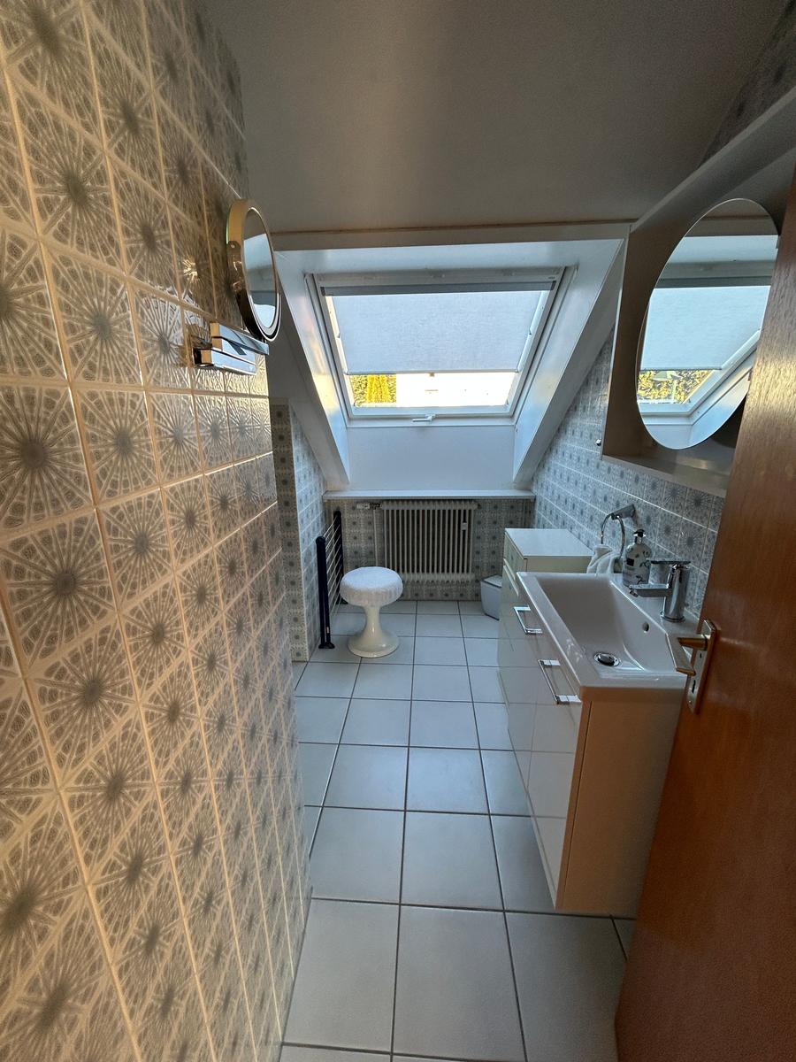 Badezimmer mit Dachfenster, Waschbecken und Toilette