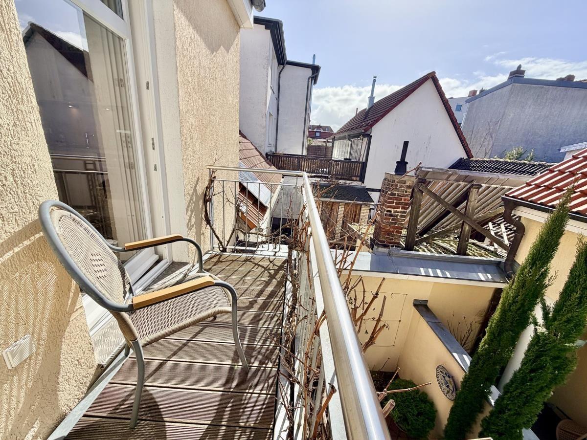 Terrasse mit Stuhl und Blick auf Dächer und Bäume
