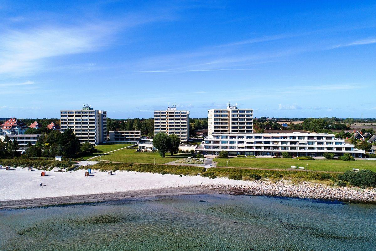 Strandfront mit mehreren Wohngebäuden und grünen Flächen