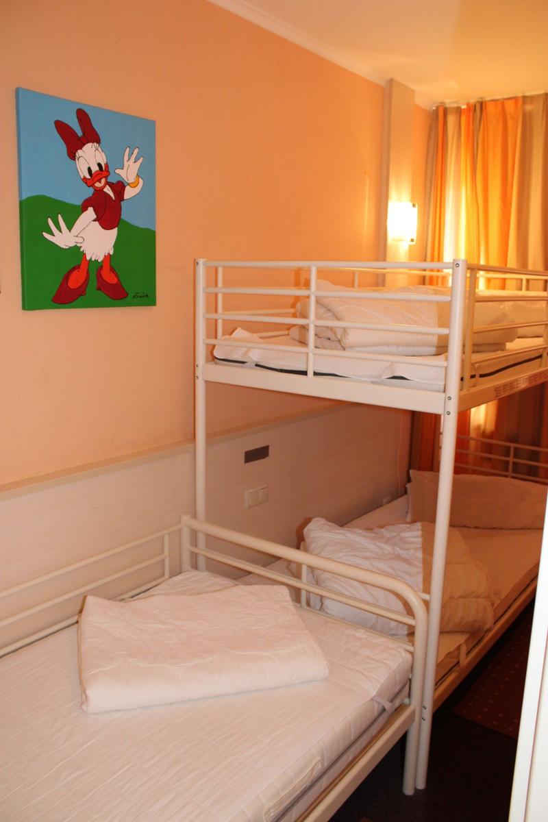 Zimmer mit Doppelstockbetten und Wandbild von Donald Duck.