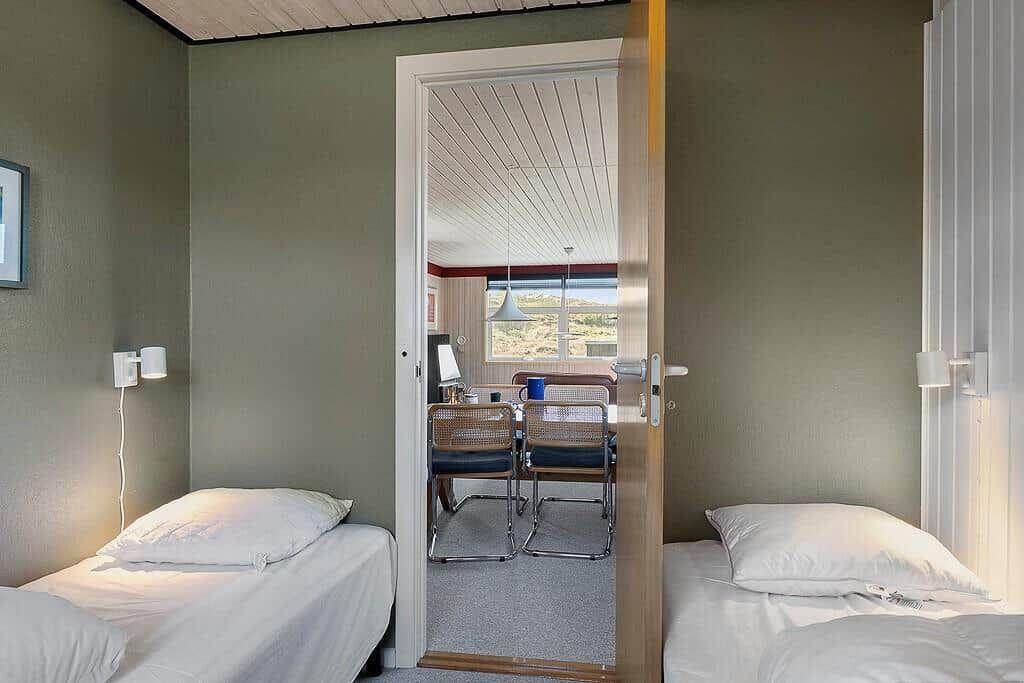 Zwei Betten im Schlafzimmer, Tür zum Essbereich mit Sicht auf Landschaft.