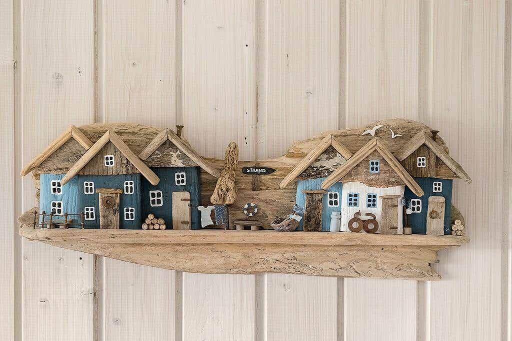 Holzdekoration mit Häusern und Strand-Schild an Wand