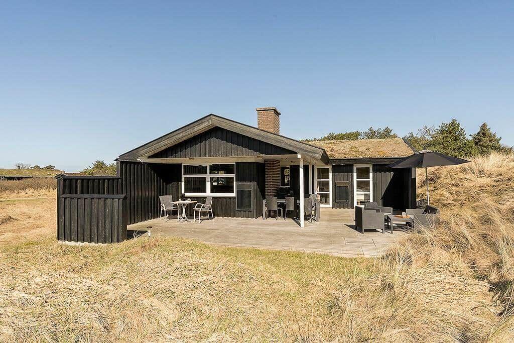 Haus mit Terrasse, Grill und Sitzgelegenheiten in Grashügeln