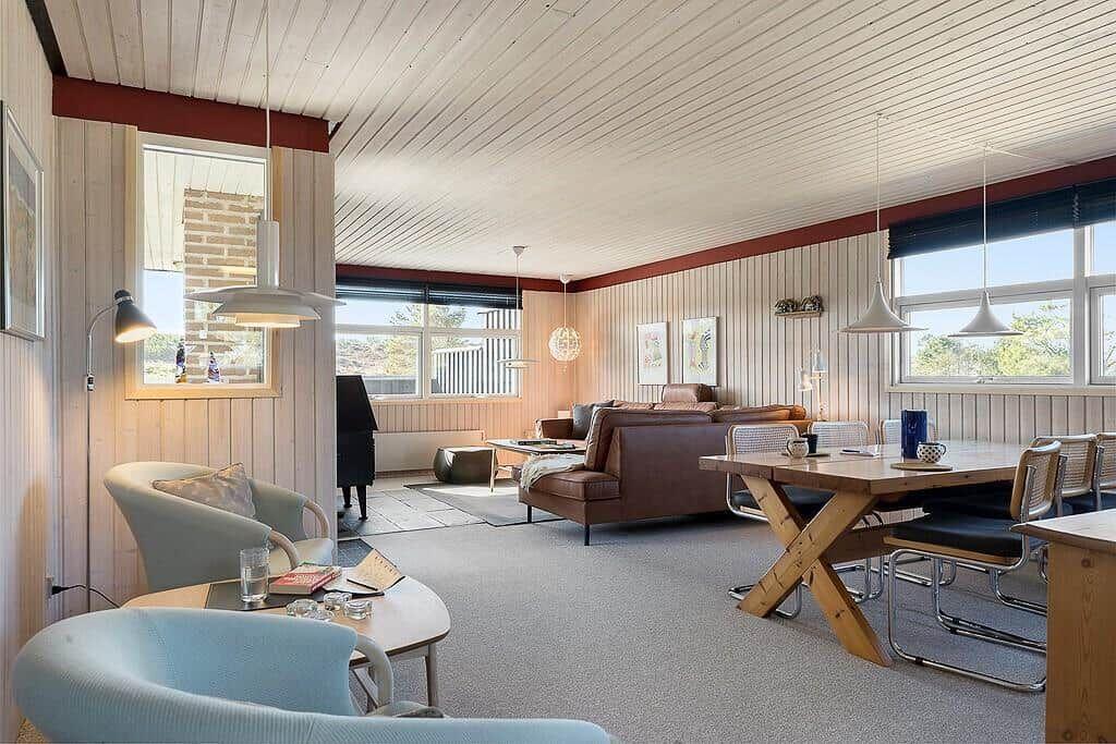 Wohn- und Essbereich mit Holztisch, Sofa und Fenstern