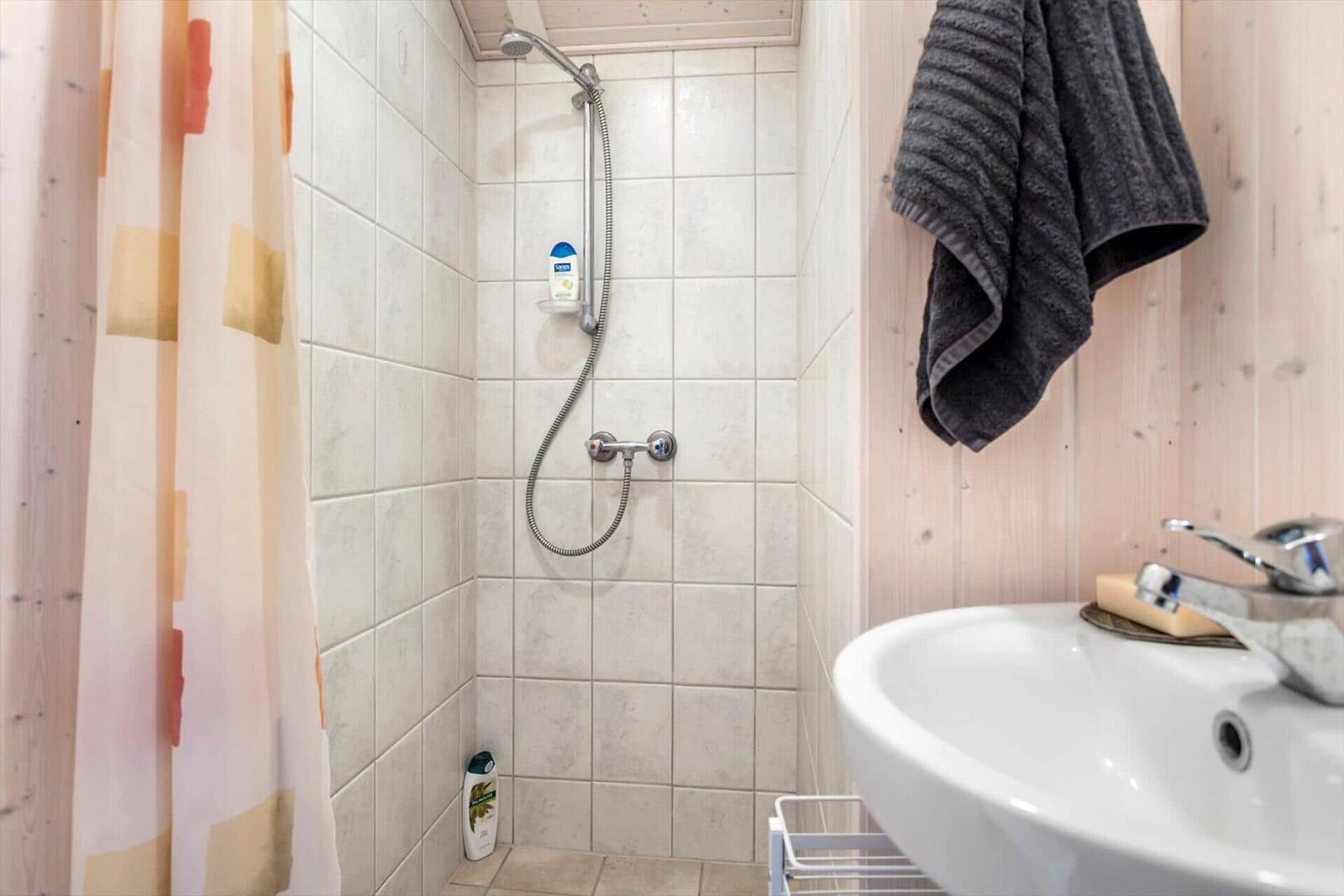 Badezimmer mit Dusche, Waschbecken und Handtuch.