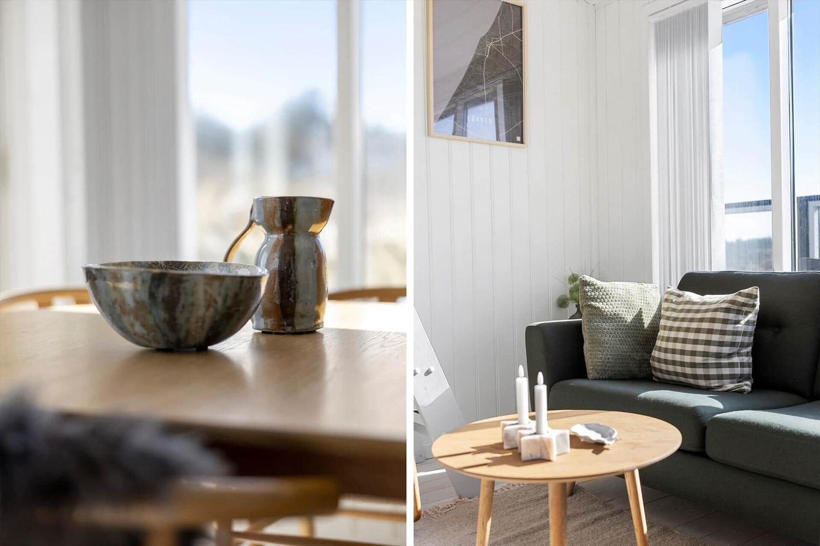Esstisch mit Schale und Karaffe. Wohnzimmer mit Sofa, Tisch und Fenster.